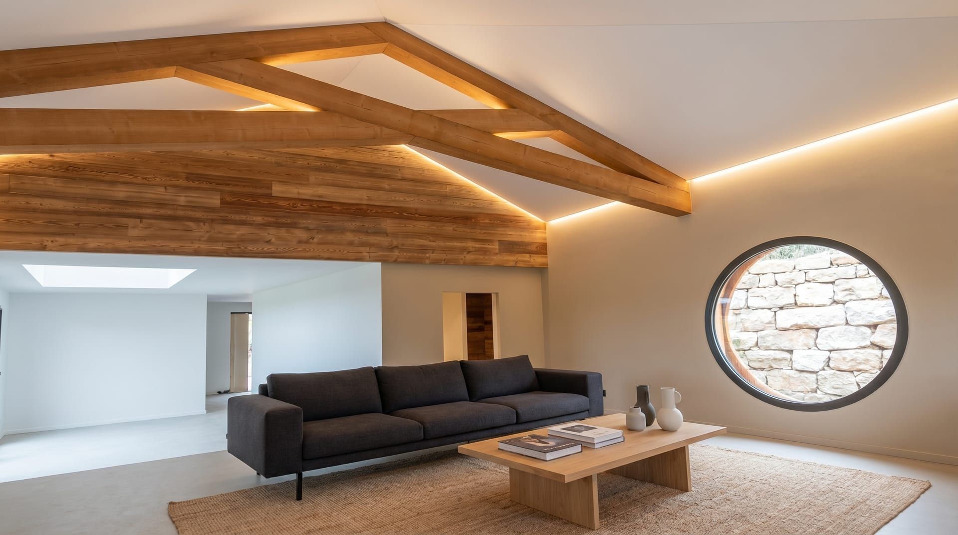 Salon avec plafond tendu satiné rétroéclairé par LED, poutres bois apparentes : réalisation Eyraud